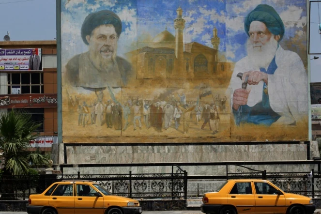 Une affiche représentant le dirigeant shiite Moqtada al-Sadr (g) et le membre du clergé shiite Mohammed Baqer al-Sadr, à Sadr City, le 14 mai 2018