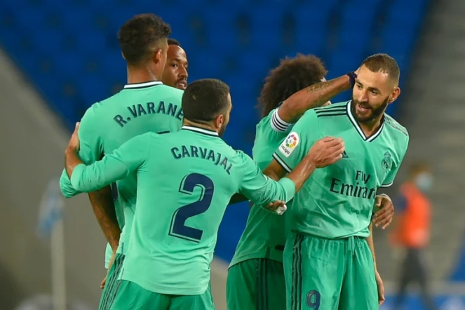 L'attaquant français du Real Madrid, Karim Benzema (d), félicité par ses coéquipiers après son but lors du match de Liga face à la Real Sociedad, à San Sebastian, le 21 juin 2020