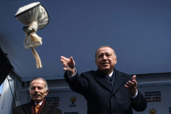 Le président turc Recep Tayyip Erdogan lance un sac de thé noir à ses partisans lors d'un meeting électoral pour les municipales, le 30 mars 2019 à Istanbul