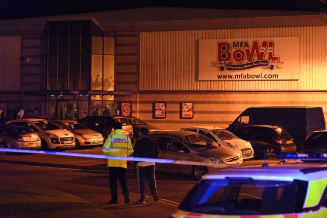 Des policiers britanniques se tiennent en faction aux abords du bowling MFA Bowl à Nuneaton (centre) où un homme armé a retenu deux employés en otage avant d'être interpellé le 22 octobre 2017