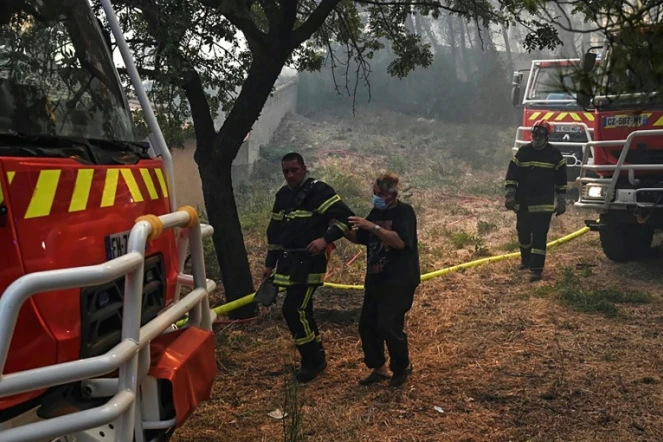 Un homme âgé est évacué par les pompiers lors d?un incendie de forêt à Martigues, le 24 août 2020