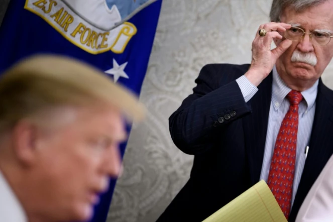Sur cette photo en date du 13 mai 2019, John Bolton, alors conseiller de Donald Trump à la Sécurité nationale, écoute le président américain lors d'un échange avec la presse à la Maison Blanche