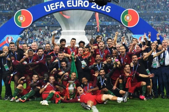 Les joueurs et personnels de l'équipe de football portugaise posent avec le trophée après avoir remporté la finale de l'Euro-2016, le 10 juillet 2016 au Stade de France, à Saint-Denis, près de Paris