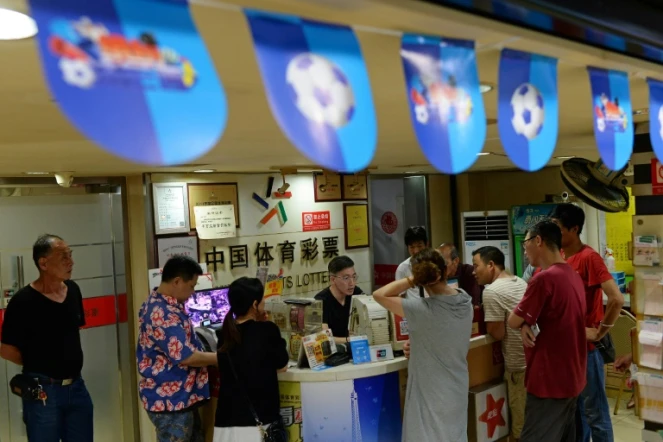 Des parieurs dans une boutique de loto sportif à Shanghai, le 2 juillet 2018