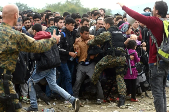 La police macédonienne tente de contenir le 18 octobre 2015 une foule de migrants au poste-frontière de Gevgelija, entre la Macédoine et la Grèce 