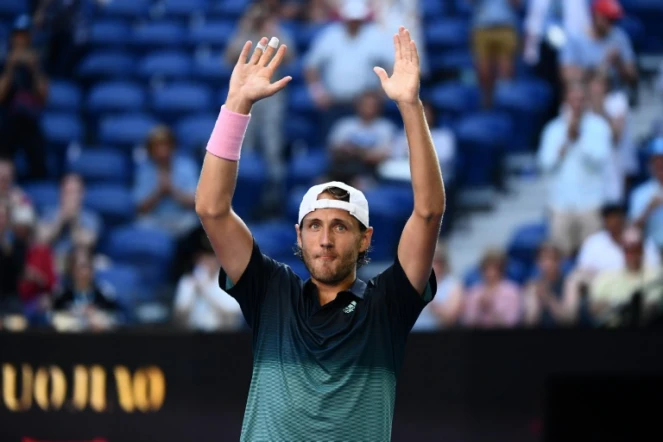 Le Français Lucas Pouille exulte bras levés après sa victoire face au Canadien Milos Raonic en quarts de finale de l'Open d'Australie, le 23 janvier 2019 à Melbourne 