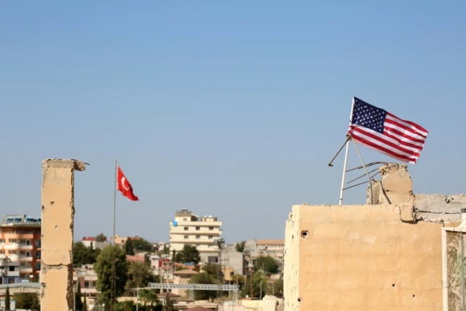 Des drapeaux turc (G) et américain (D) flottent le 17 septembre 2016 au-dessus du village syrien de Tal Abyad, à l'extrême nord du pays près de la frontière turque