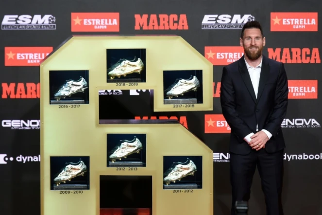 Le capitaine du Barça Lionel Messi pose avec ses six souliers d'or européens, le 16 octobre 2019 à Barcelone   