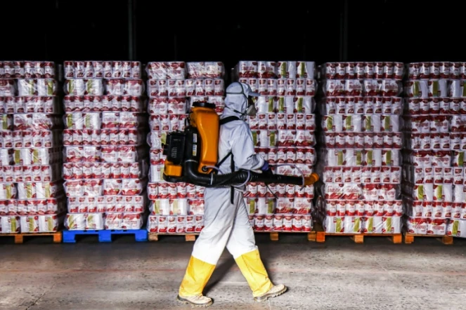 Un homme désinfecte des produits entreposés à  Curitiba, au Brésil, le 19 uin 2020
