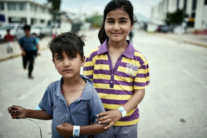 Des enfants portant un bracelet d'identificaton dans un camp pour migrants à l'ancien aéroport d'Athènes le 13 juin 2016