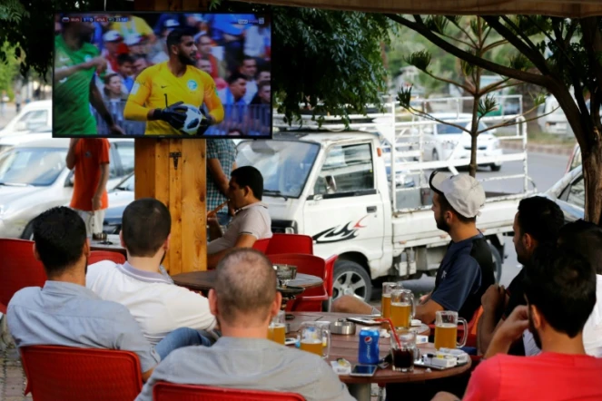 Des Syriens suivent la retransmission du match d'ouverture du Mondial-2018 de football entre la Russie et l'Arabie saoudite au café Moscou à Lattaquié,  dans l'ouest de la Syrie, le 14 juin 2018