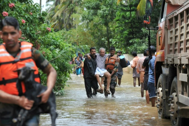 Les secouristes évacuent une victime des inondations dans le village de Mala, au sud de l'Inde, le 19 août 2018