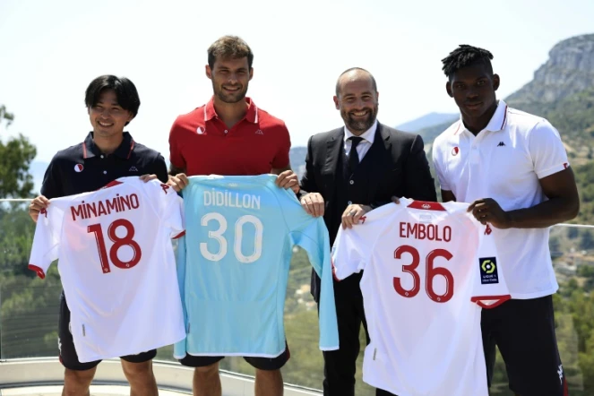 Trois des recrues de Monaco, les attaquants Takumi Minamino (g) et Breel Embolo (d), le gardien Thomas Didillon, posent avec le directeur sportif du club Paul Mitchell, le 20 juillet 2022 à La Turbie
