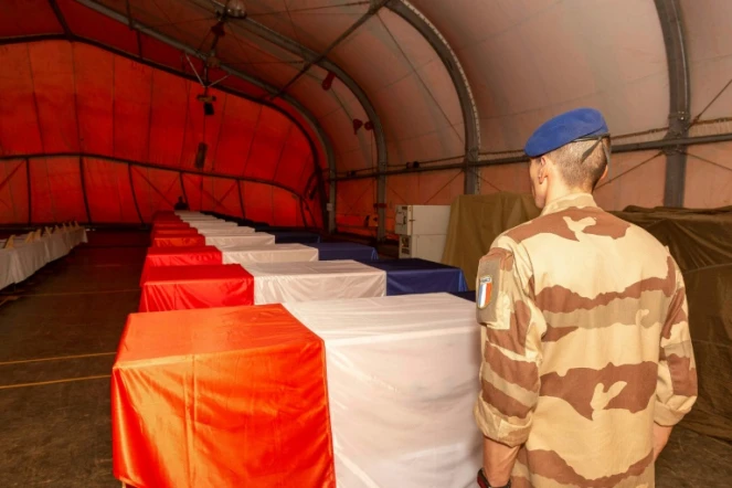 Un soldat français devant les cercueils des 13 militaires de la Force Barkahne morts dans un accident d'hélicoptère, à Gao (Mali), le 27 novembre 2019 (photo du Sirpa, Service d'information et de relations publiques des armées)