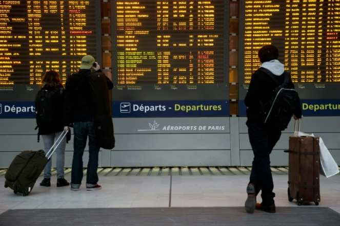 Des passagers devant le tableau des départs le 26 janvier 2016 à l'aéroport Charles-de-Gaulle à Roissy