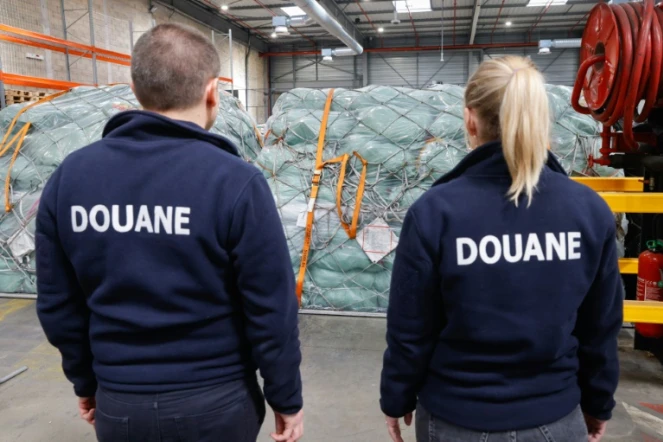Des douaniers devant des colis de fret aérien dans un entrepôt de l'aéroport Roissy-Charles-de-Gaulle, au nord de Paris, le 29 avril 2025