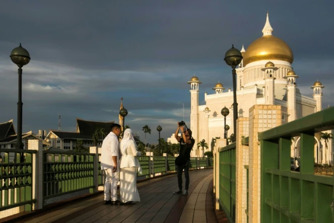 Un couple de jeunes mariés se fait photographier le 1er avril 2019 à la mosquée Sultan Omar Ali Saifuddien de Bandar Seri Begawan, la capitale du sultanat de Brunei.
