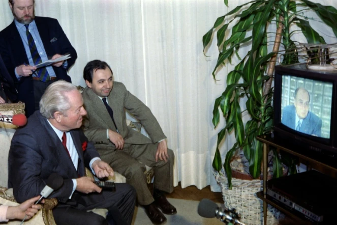 Le numéro un du Front national Jean-Marie Le Pen et Bruno Mégret, le numéro deux du mouvement, regardent le président François Mitterrand annoncer sa candidature à l'élection présidentielle à la télévision, le 22 mars 1988, dans sa maison de Saint-Cloud