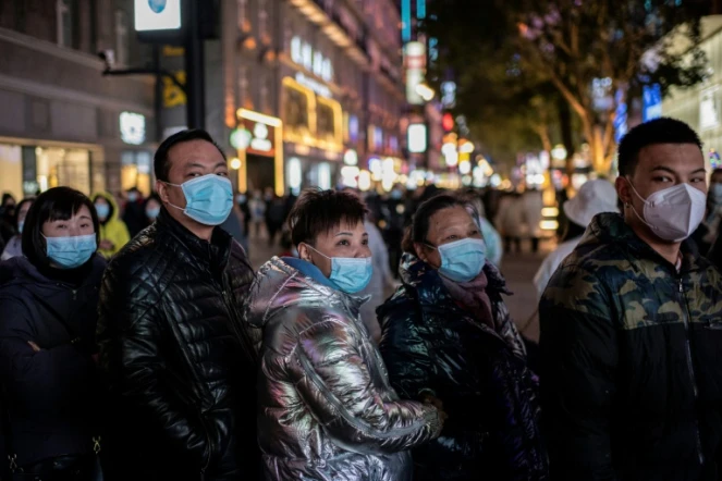Des habitants regardent un écran 3D géant le 10 janvier 2021 à Wuhan, à la veille du premier anniversaire du 1er décès de coronavirus annoncé par la Chine