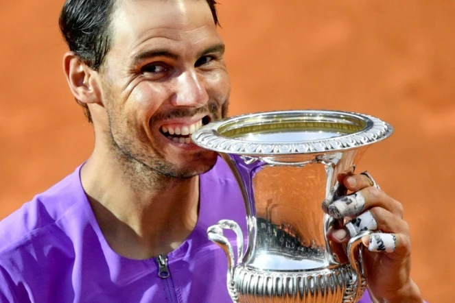 L'Espagnol Rafael Nadal mord son trophée du Masters 1000 de Rome après sa victoire en finale sur le Serbe Novak Djokovic, le 16 mai 2021