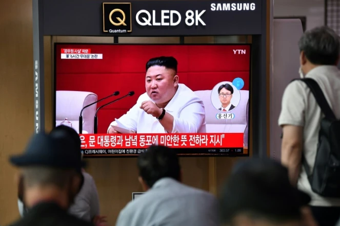 Des Sud-Coréens regardent des images du leader nord-coréen Kim Jong Un sur un écran de télévision dans une gare de Séoul, le 25 septembre 2020