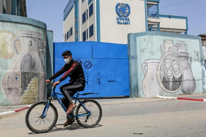 Un palestinien circule en vélo devant les portes fermées d'une école gérée par l'Agence de l'ONU pour les réfugiés palestiniens (Unrwa) à Rafah, le 6 avril 2021