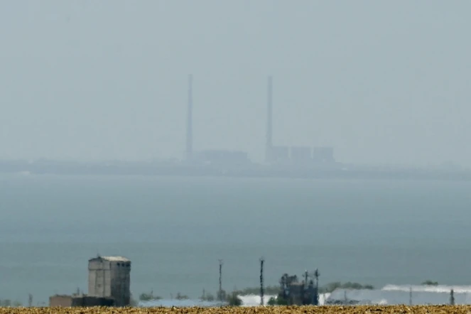 La centrale nucléaire de Zaporijjia (en arrière-plan), dans le sud de l'Ukraine, occupée par les Russes et observée depuis Vyschetarasivka, de l'autre côté du Dniepr, le 13 août 2022
