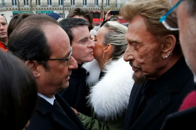 Le président Francois Hollande parle avec Johnny Hallyday tandis que sa femme Laetitia embrasse le Premier ministre Manuel Valls à la fin d'une cérémonie le 10 jancier 2016, un an après l'attentat contre Charlie Hebdo