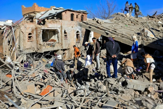 Des Yéménites inspectent les décombres après des frappes de la coalition militaire dirigée par l'Arabie saoudite sur Sanaa, dirigée par les Houthis, le 18 janvier 2022