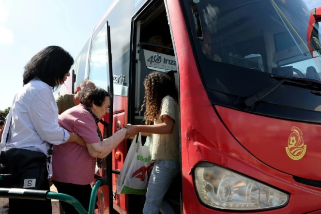 Des Israéliens âmontent à bord d'un bus pour évacuer la ville de Sderot, dans le sud d'Israël, vers des zones plus sûres, le 15 octobre 2023