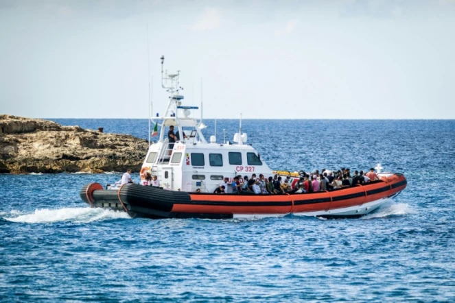 Des migrants embarquent sur un navire militaire italien à Lampedusa