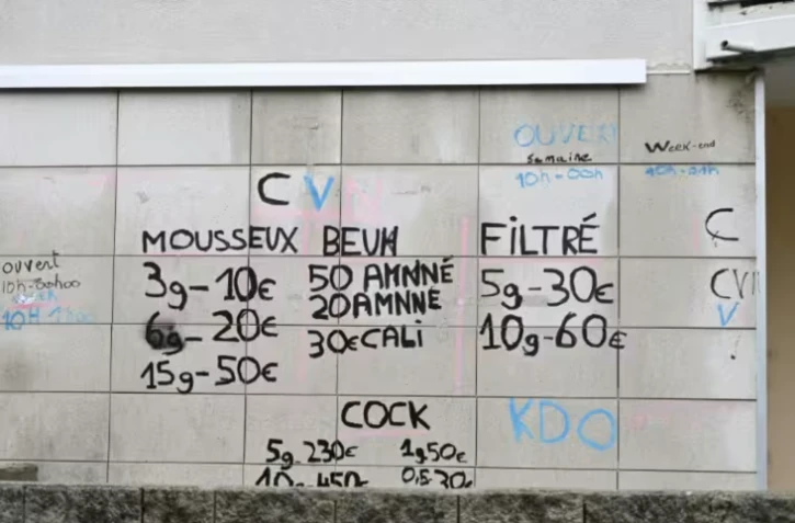 Des inscriptions sur le prix des drogues sur un mur du quartier des Cévennes à Alès, lors d'une visite de points de deal par des magistrats du parquet français, le 22 janvier 2026 dans le Gard ( AFP / Sylvain THOMAS )