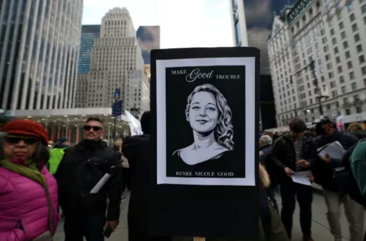 Une personne brandit un portrait de Renee Nicole Good, tuée par un policier de l'immigration à Minneapolis, lors d'une manifestation à New York, le 11 janvier 2025 ( AFP / TIMOTHY A. CLARY )