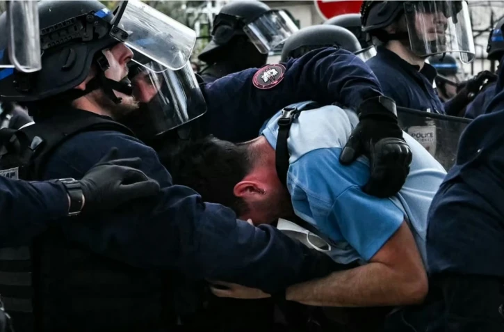 Un manifestant est interpellé par des agents de la police anti-émeute lors d'une manifestation de lycéens à Paris, le 13 octobre 2026. (LOU BENOIST / AFP)