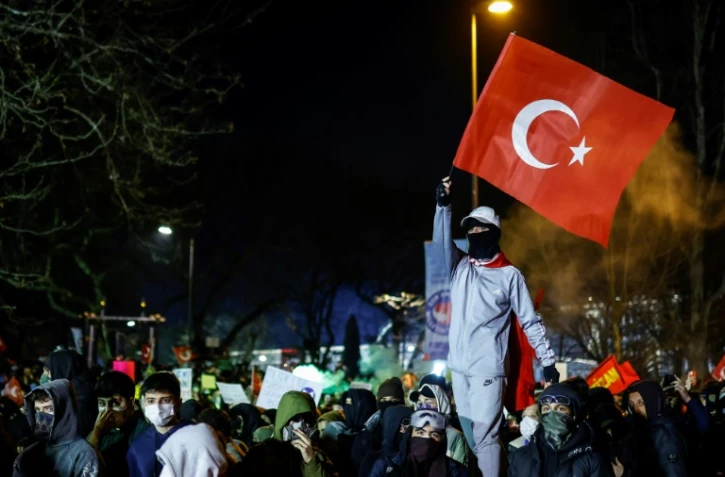 Un manifestant agite le drapeau national de la Turquie lors d'une manifestation devant l'hôtel de ville d'Istanbul pour soutenir le maire d'Istanbul Ekrem Imamoglu le 22 mars 2025