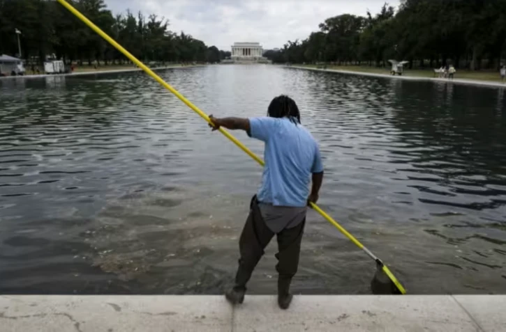 Un ouvrier nettoie l'eau du bassin réfléchissant du Lincoln Memorial à Washington, le 22 juin 2026 ( AFP / Kent Nishimura )