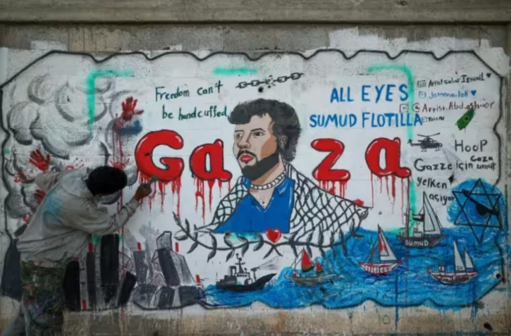 Un artiste peint une fresque dénonçant l'interception par Israël de la flottille pour Gaza, le 19 mai 2026 à Nousseirat, dans le centre de la Bande de Gaza ( AFP / Eyad Baba )