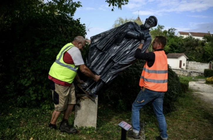 Des employés municipaux déboulonnent une statue de l'abbé Pierre, à Norges-la-Ville, le 17 septembre 2024 en Côte d'Or ( AFP / JEFF PACHOUD )