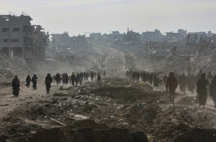 Des dizaines de déplacés palestiniens prennent la route à Jabalia dans la nord de la bande de Gaza, pour retourner chez eux, le 19 janvier 2025 ( AFP / Omar AL-QATTAA )