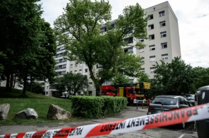 Des pompiers et policiers près d'un immeuble où s'est déclenché un incendie criminel à Décines-Charpieu, près de Lyon, le 11 mai 2026 ( AFP / JEFF PACHOUD )