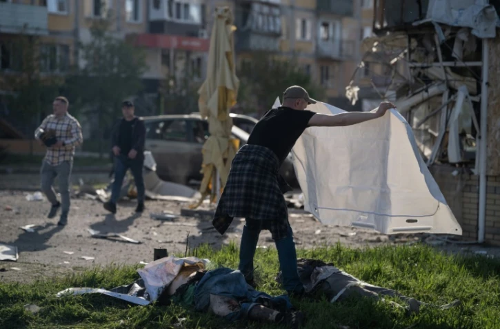 Un homme couvre d'un drap les corps de victimes de frappes russes à Kramatorsk, dans l'Est de l'Ukraine, le 5 mai 2026