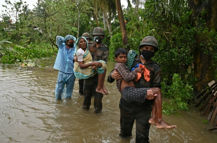 Des membres de l'armée indienne portent secours à des villageois le 26 mai 2021 à Ramnagar dans l'est de l'Inde, après des inondations causées par le cyclone Yaas