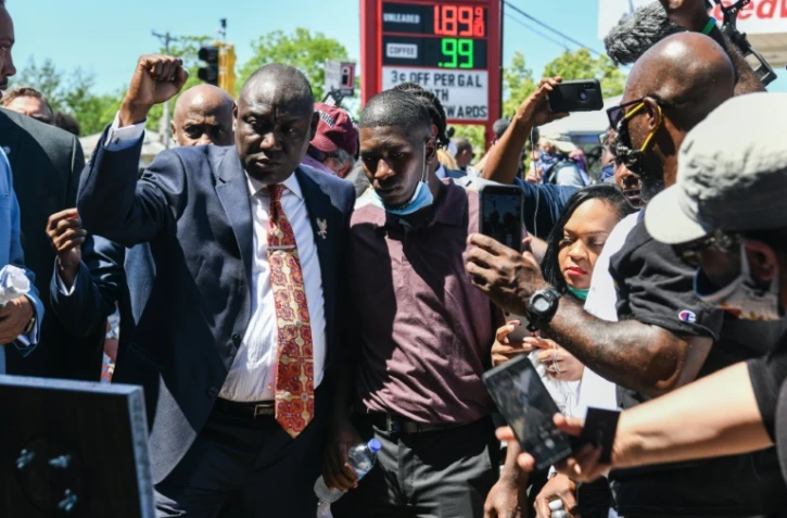 Le fils de George Floyd, Quincy Mason Floyd (au centre) et l'avocat de la famille, Ben Crump, le poing levé, à Minneapolis le 3 juin 2020
