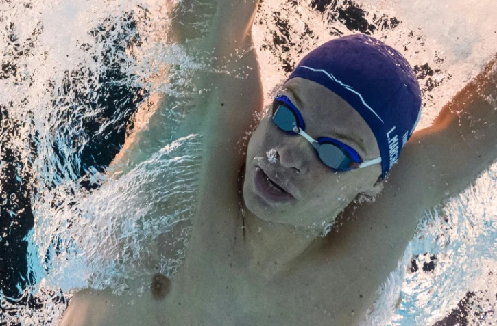 Vue prise sous l'eau du nageur français Léon Marchand lors des séries du 400 m 4 nages des JO, le 28 juillet 2024 à La Defense Arena