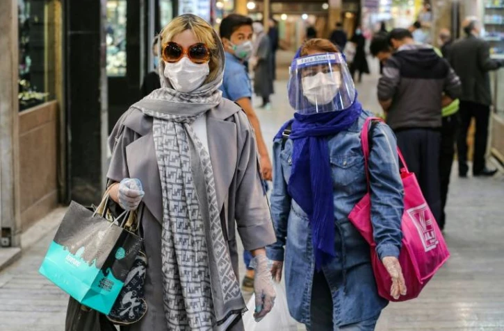 Des femmes font leurs courses avec masques et gants, à Téhéran, le 25 avril 2020 