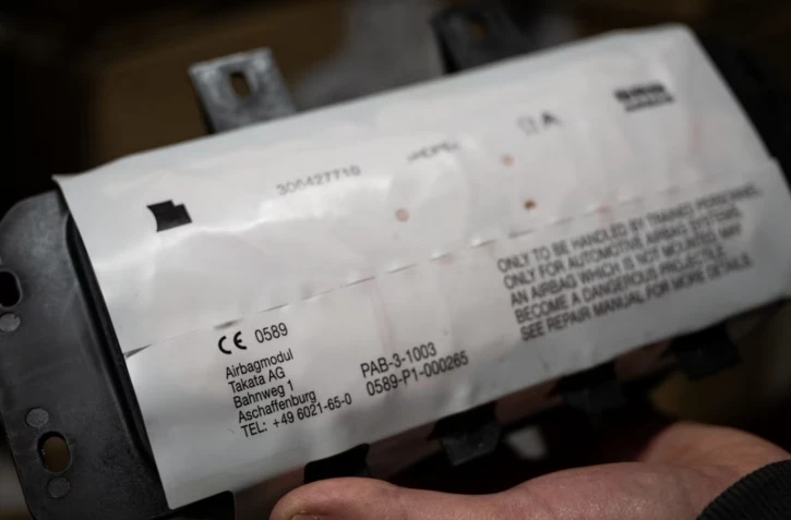 Un mécanicien tient un module d'airbag fabriqué par l'équipementier japonais Takata, dans un garage à Mulhouse (Haut-Rhin), le 19 février 2025. (SEBASTIEN BOZON / AFP)
