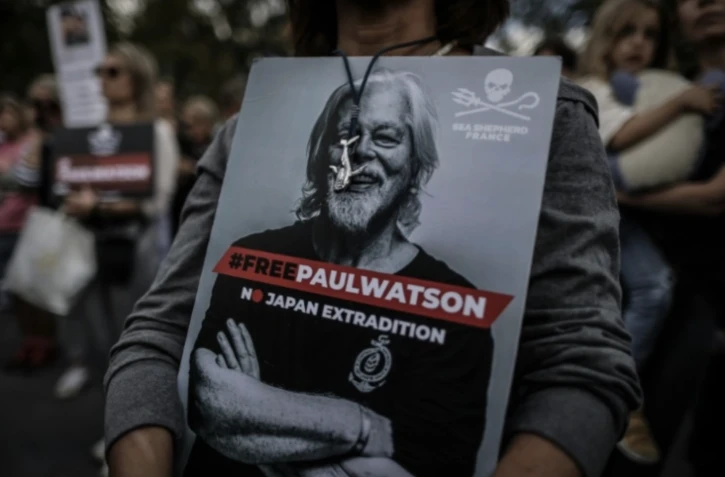 Une femme tient une pancarte avec l'inscription "#LibérezPaulWatson - Pas d'extradition vers le Japon" écrite sur une photo de Paul Watson, fondateur de l'ONG Sea Shepherd, lors d'une manifestation de soutien à Paris le 4 septembre 2024 ( AFP / Thibaud MORITZ )