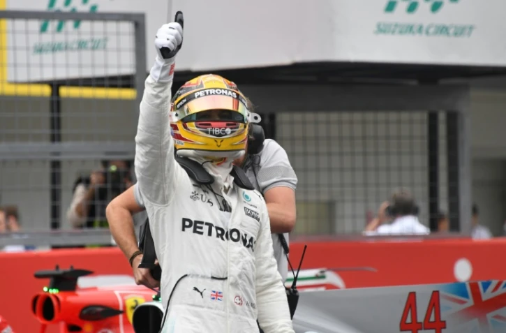 Le Britannique Lewis Hamilton (Mercedes) bras levé après avoir obtenu la pole position du GP du Japon sur le circuit de Suzuka, le 7 octobre 2017
