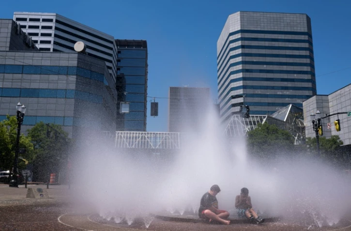 Des enfants se refraîchissent dans une fontaine à Portland, dans l'Ouest des Etats-Unis touché par une vague de chaleur extrême, le 27 juin 2021