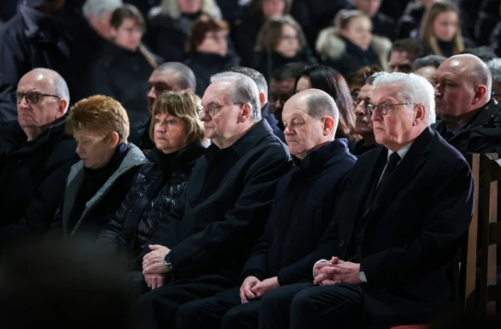 Le chancelier allemand Olaf Scholz (deuxième en partant de la droite) et le président de l'Allemagne Frank-Walter Steinmeier (tout à droite), le 21 décembre 2024 dans une église à Magdebourg, dans l'est de l'Allemagne
